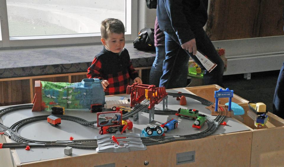 Two-year-old Hunter Bellman spends time at a model railroad table in the children's section of the new library building in Rittman.