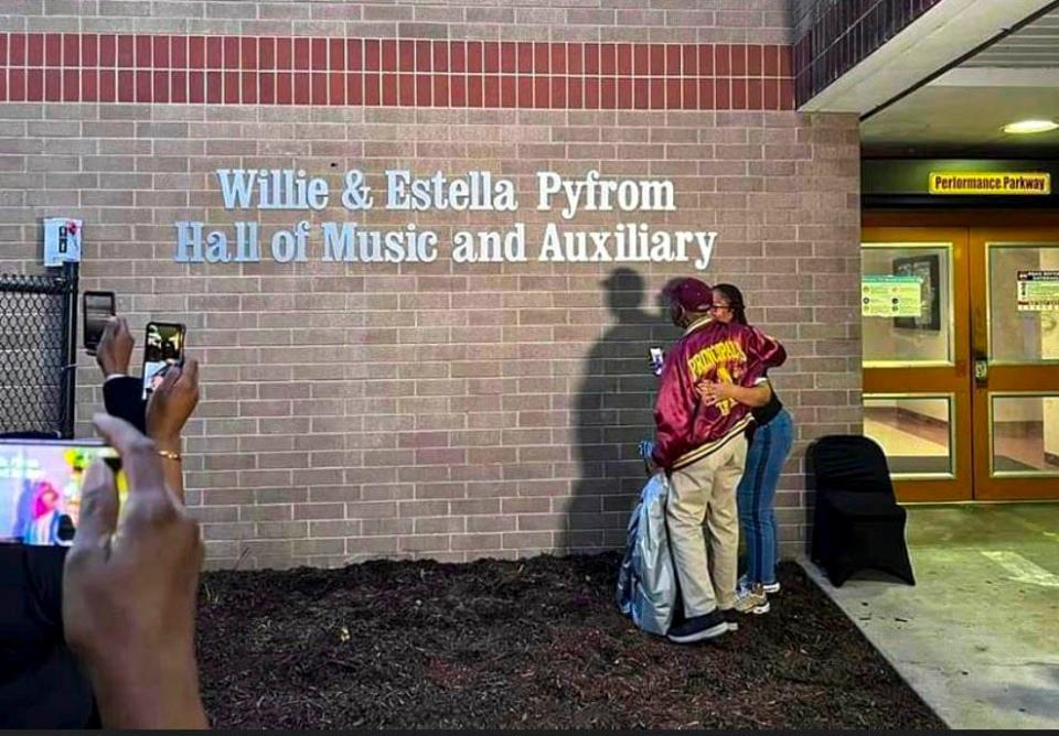 Willie Pyfrom and his daughter, Mia, unveil the silver lettering naming the music hall at Glades Central High School for him and his wife Estella on Friday, Dec. 9, 2022. The couple taught at the Belle Glade school for decades.