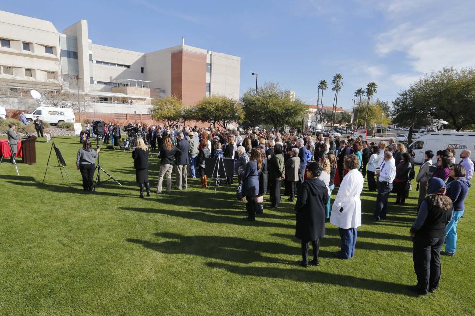 People assemble on the lawn outside University of Arizona Medical Center during a remembrance ceremony on the third anniversary of the Tucson shootings, Wednesday, Jan. 8, 2014, in Tucson, Ariz. Six people were killed and 13 wounded, including U.S. Rep. Gabrielle Giffords, D-Ariz., in the shooting rampage at a community event hosted by Giffords. The victims were all transported to the medical center in 2011. (AP Photo/Matt York)