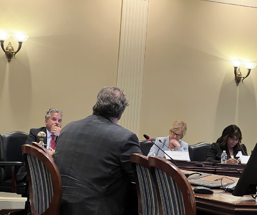 At left, Jim Kercheval, a former Washington County commissioner, listens to Ward McCarragher, center, of the American Public Transportation Association, during a hearing of the newly formed Maryland Commission on Transportation Revenue and Infrastructure Needs in Annapolis on August 24, 2023. Kercheval is one of about 30 commissioners.