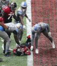 Detroit Lions players point at the football held by Atlanta Falcons' Todd Gurley during the fourth quarter of an NFL football game Sunday, Oct. 25, 2020, in Atlanta. Gurley saw a tantalizing path to the end zone and couldn't help himself. He tried to fall down, but it was too late. Gurley landed on the goal line for a touchdown that, as it turned out, led to another stunning loss for the Atlanta Falcons. (Curtis Compton/Atlanta Journal-Constitution via AP)