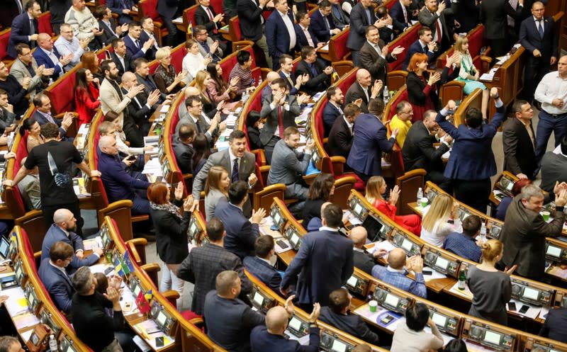 Ukrainian lawmakers react after voting to remove a ban on the sale of farmland, at the parliament building in Kiev