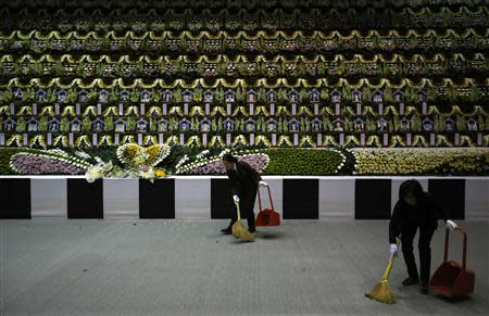 Employees sweep the floor in front of a temporary group memorial altar for victims of capsized passenger ship Sewol, in Ansan April 24, 2014. REUTERS/Kim Hong-Ji