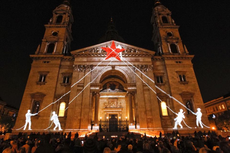 FILE - In this Friday Nov. 4, 2016 file photo, images are projected during the commemoration of the 60th anniversary of the Hungarian revolution and the invasion of Soviet troops and fight against communism and soviet rule, at St. Stephen's Basilica in Budapest, Hungary. For Hungary, a pro-Russian leader in the White House offers hope the Western world might end the sanctions imposed over Russia’s annexation of Crimea and its role in eastern Ukraine. Many Poles, instead, fear a U.S-Russian rapprochement under Trump could threaten their own security interests. To most Poles, NATO represents the best guarantee for an enduring independent state in a difficult geographical neighborhood. (Zsolt Szigetvary/MTI via AP, File)