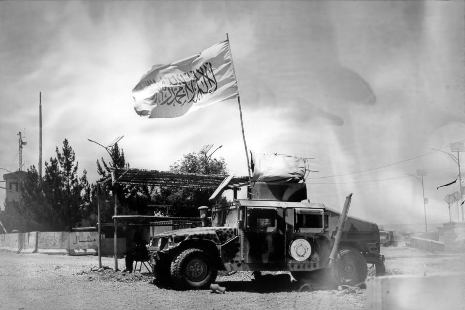 A Taliban flag waves from a U.S. military vehicle which had been used during the years of military intervention, on the outskirts of Kabul, Afghanistan, Tuesday, June 21, 2023. (AP Photo/Rodrigo Abd)