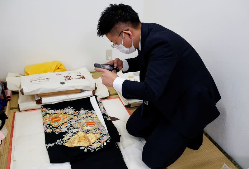 Buysell Technologies staff takes a photo of Mitsuko Iwama's kimono for assessment in Tokyo