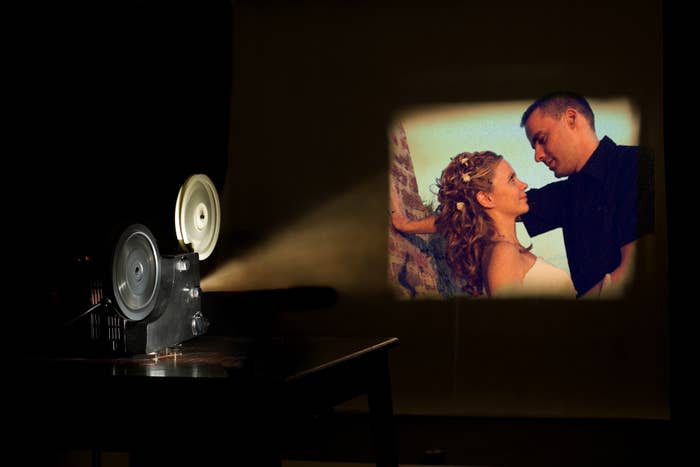 A film projector shows an image of a couple gazing at each other affectionately