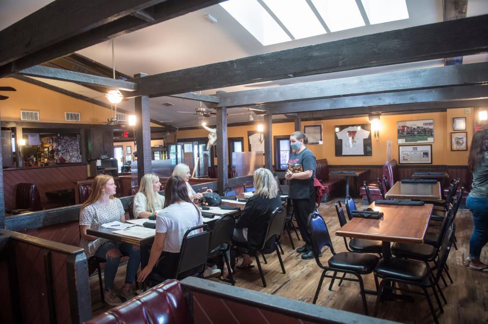 A waitress serves customers last March at TBonz Steakhouse on Washington Road. Co-owner Henry Scheer said the COVID-19 pandemic has brought ups and downs with staffing.