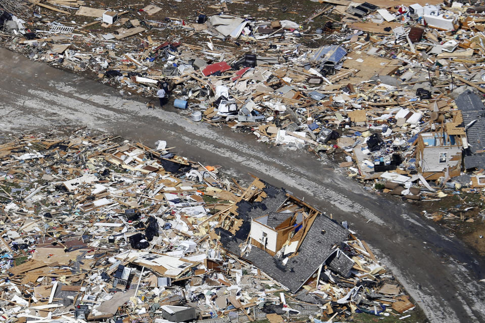 FILE — In this March 3, 2020, file photo, a road separates properties filled with debris near Lebanon, Tenn. It has been nearly a year since deadly tornados tore across Nashville and other parts of Tennessee as families slept. The March 3 storm killed more than 20 people, some in their beds, as it struck after midnight. More than 140 buildings were destroyed across a swath of Middle Tennessee, burying people in rubble and basements. (AP Photo/Mark Humphrey, File)