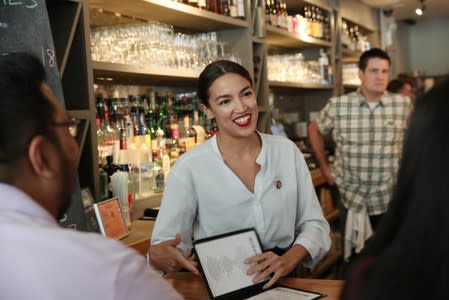 Rep. Alexandria Ocasio-Cortez (D-NY) speaks with people after taking an order in support of One Fair Wage at The Queensboro restaurant in New York