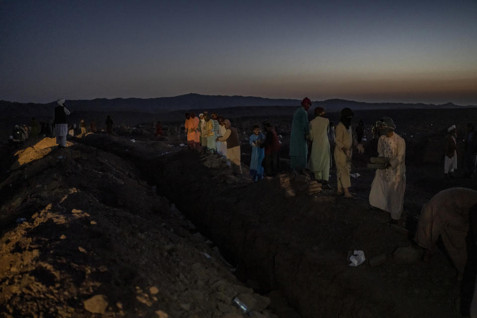 Afghans bury hundreds of people killed in an earthquake at a burial site, outside a village in Zenda Jan district in Herat province, western of Afghanistan, Monday, Oct. 9, 2023. Saturday's deadly earthquake killed and injured thousands when it leveled an untold number of homes in Herat province. (AP Photo/Ebrahim Noroozi)