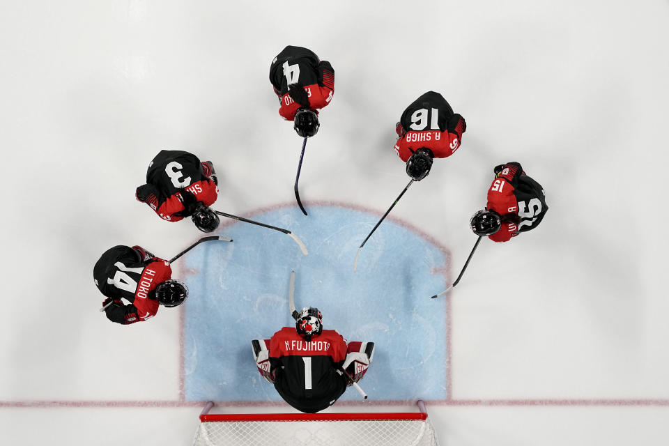 Japan players gather before a preliminary round women's hockey game against Sweden at the 2022 Winter Olympics, Thursday, Feb. 3, 2022, in Beijing. (AP Photo/Petr Josek)