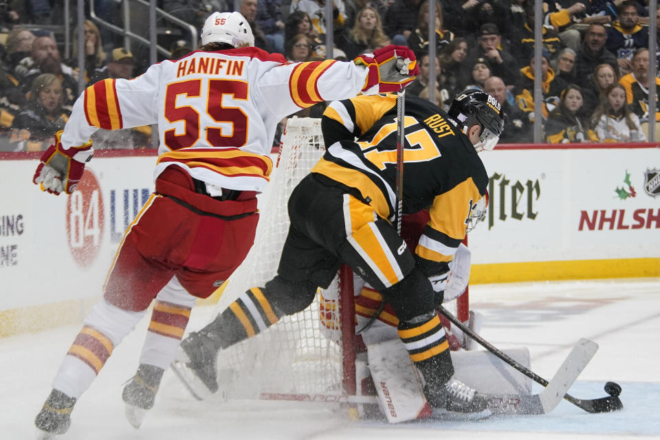 Pittsburgh Penguins' Bryan Rust (17) can't get a shot off in front of Calgary Flames goaltender Dan Vladar, rear, with Noah Hanifin (55) defending during the second period of an NHL hockey game in Pittsburgh, Wednesday, Nov. 23, 2022. (AP Photo/Gene J. Puskar)
