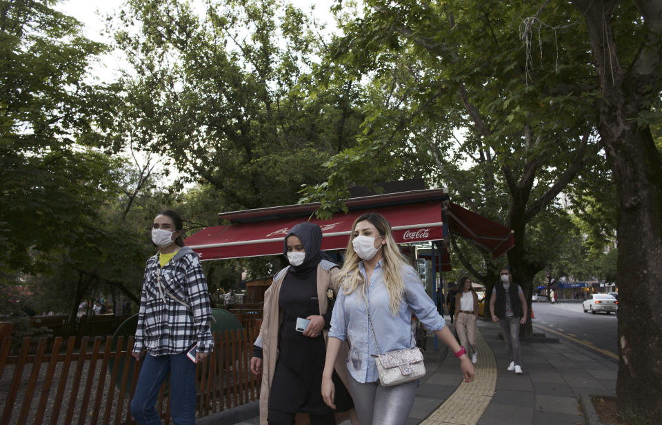 People wearing face masks to protect against the new coronavirus, walk along a popular street, in Ankara, Turkey, Saturday, June 13, 2020. Turkey's President Recep Tayyip Erdogan has revealed Tuesday new plans to ease restrictions in place to curb the spread of the coronavirus, including the July 1 reopening of theaters, cinemas and other entertainment centers. (AP Photo/Burhan Ozbilici)