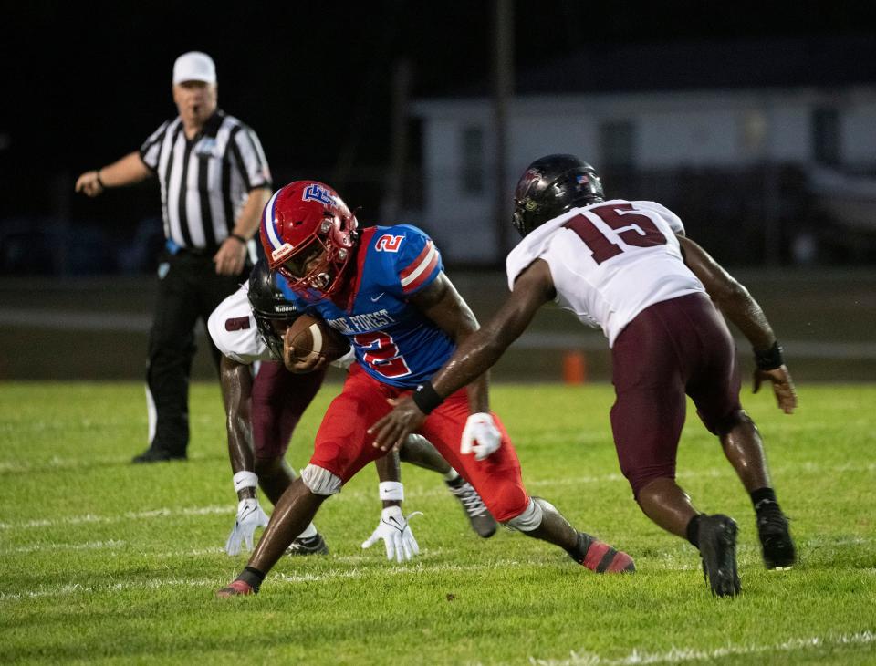 Pine Forest's Miequle Brock (No. 2) tries to slip past the Navarre defense during a game on Sept. 1, 2023 from Lon R. Wise Stadium