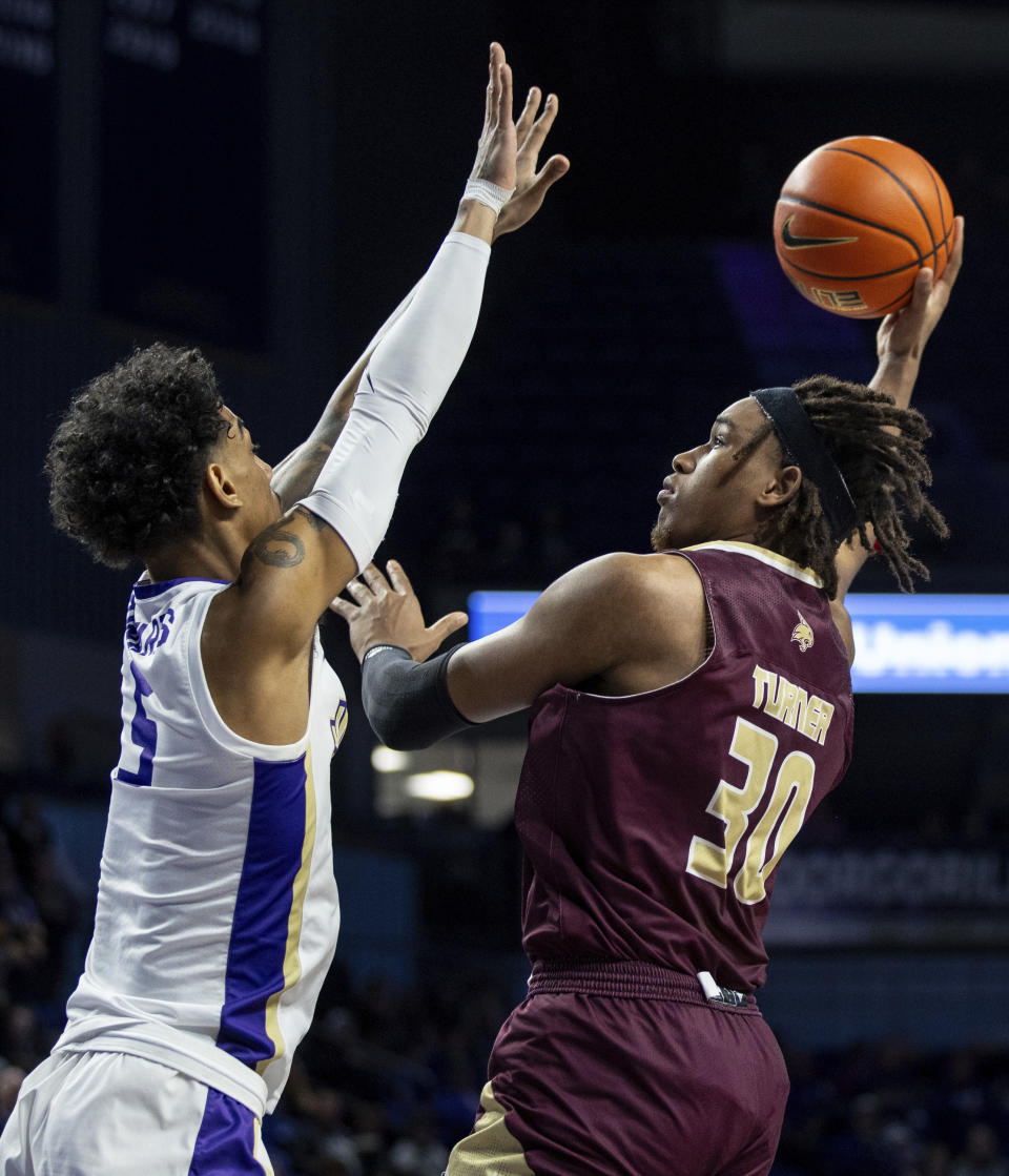 Texas State forward Christian Turner (30) goes up for a shot against James Madison guard Terrence Edwards Jr. (5) during the first half of an NCAA college basketball game in Harrisonburg, Va., Saturday, Dec. 30, 2023. (Daniel Lin/Daily News-Record via AP)