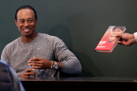 Golfer Tiger Woods sits down to sign copies of his new book "The 1997 Masters: My Story" at a book signing event at a Barnes & Noble store in New York City, New York, U.S., March 20, 2017. REUTERS/Mike Segar