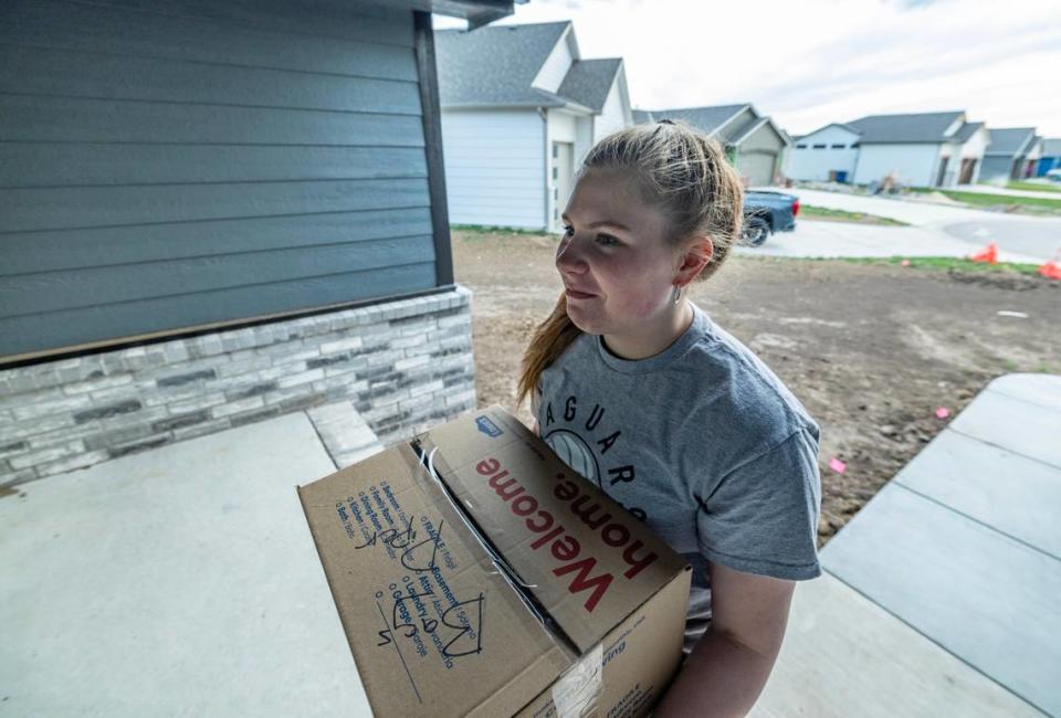 Piper Batcheller moves a box of her belongings into her family’s newly built home in Andover on Thursday. The Batcheller home was destroyed by the April 29, 2022 tornado and now Chris Batcheller and his two kids are about ready to move in.