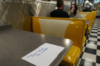 FILE - In this Nov. 17, 2020, file photo, a closed sign is posted on this table notifying diners in keeping with social distancing guidelines at Linda's Soda Bar and Grill in the Sutter County community of Yuba City, Calif. Not willing to wait for more federal help, states have been moving ahead with their own coronavirus relief packages. Maryland and California recently moved forward with help for the poor, the jobless, small businesses and those needing child care. (AP Photo/Rich Pedroncelli, File)