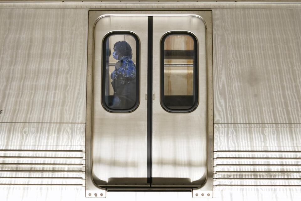 A passenger boards a train at Washington Metro's Dupont Circle station, Friday, April 23, 2021, in Washington. As President Joe Biden urges more federal spending for public transportation, transit agencies decimated by COVID-19 are struggling with a new uncertainty: how to win passengers back. (AP Photo/Patrick Semansky)