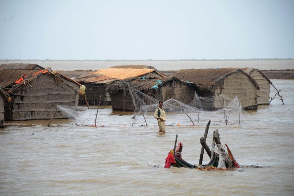 A man wades through water as cyclone Biparjoy rises sea level in a coastal area in Sujawal of Pakistan’s Sindh province (AFP via Getty Images)