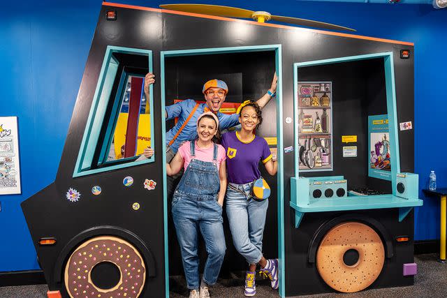 <p>Moonbug Entertainment</p> Blippi posing in a food truck with Ms. Rachel and Meekah