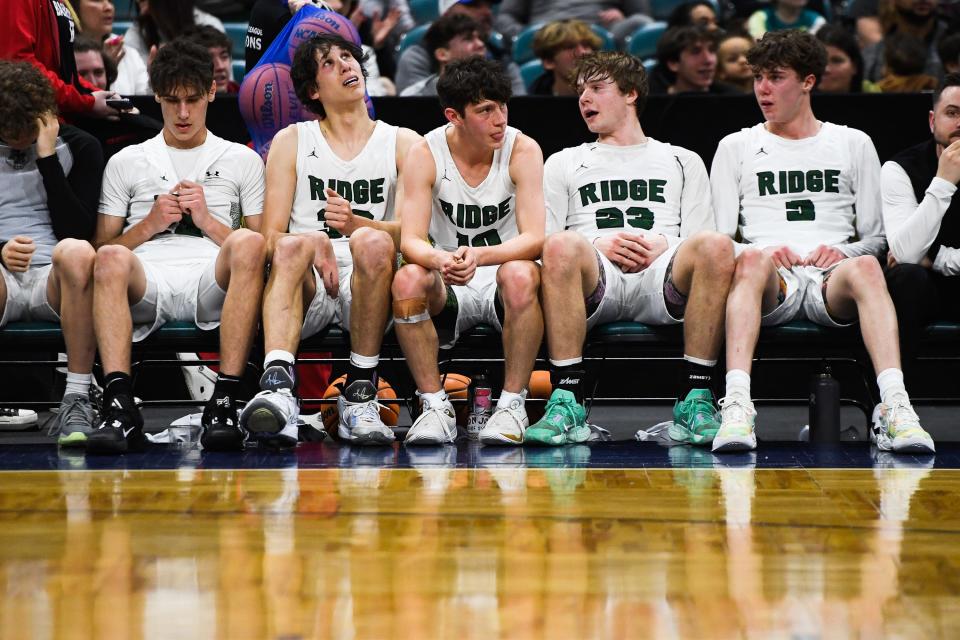 Fossil Ridge boys basketball players react on the bench near the end of the 6A state championship against Denver East at the Denver Coliseum on Saturday, March 11, 2023, in Denver, Colo. The SaberCats lost 82-61.