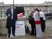 <p>Demonstrators stand next to a cardboard cut-out of President Trump and a sign reading “Trump the Legend” in London, July 14, 2018. (Photo: Yves Herman/Reuters) </p>