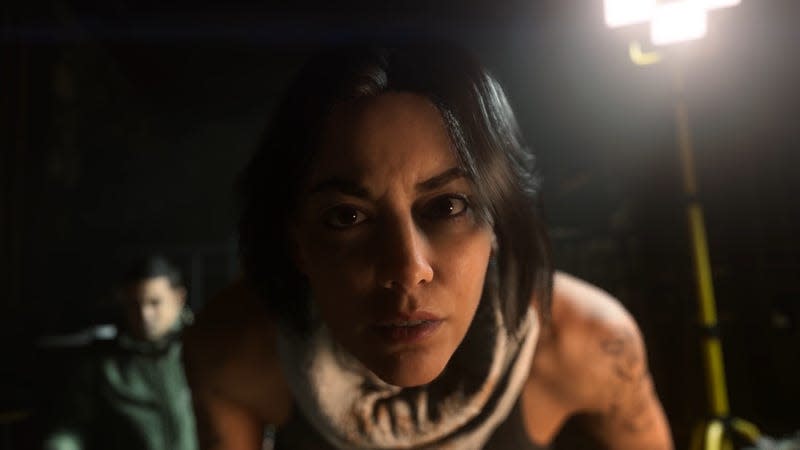 Valeria leans in to interrogate the player.