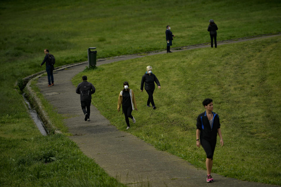 People, some wearing face masks to protect against coronavirus exercise along Vuelta del Castillo park, in Pamplona, northern Spain, Saturday, May 2, 2020. Spain relaxed its lockdown measures Saturday, allowing people of all ages to leave their homes for short walks or exercise for the first time since March 14. (AP Photo/Alvaro Barrientos)