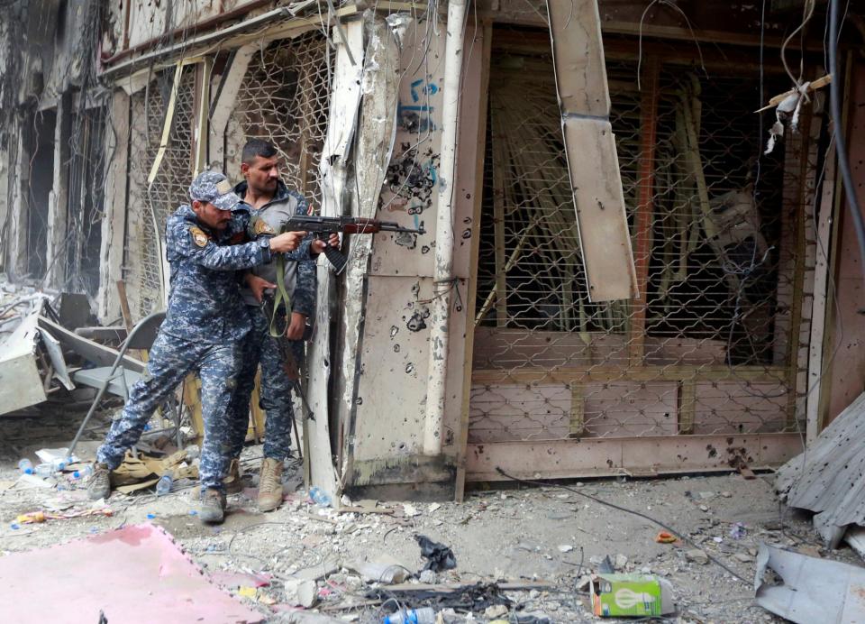 An Iraqi fighter fires against Islamic State militants