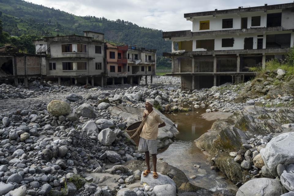 Kali Prasad Shrestha, 57, stands near Kathmandu, Nepal, Sunday, Sept. 15, 2024, on the spot where his house once stood before it was swept away by floods in 2021.(AP Photo/Niranjan Shrestha)