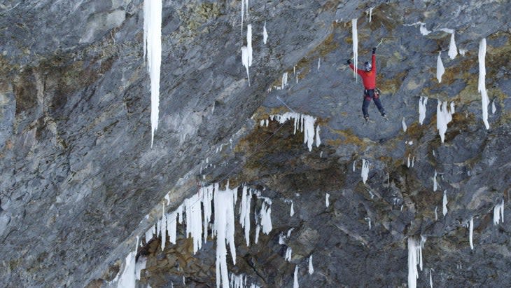 Will Gadd hangs from his ice tools as he ascends Helmcken Falls.