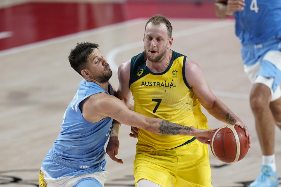 Argentina's Nicolas Laprovittola, left, tries to steal the ball from Australia's Joe Ingles (7) during a men's basketball quarterfinal round game at the 2020 Summer Olympics, Tuesday, Aug. 3, 2021, in Saitama, Japan. (AP Photo/Charlie Neibergall)