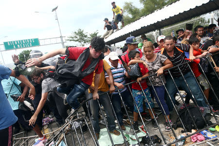 Honduran migrants, part of a caravan trying to reach the U.S., storm a border checkpoint in Guatemala, in Ciudad Hidalgo, Mexico October 19, 2018. REUTERS/Edgard Garrido