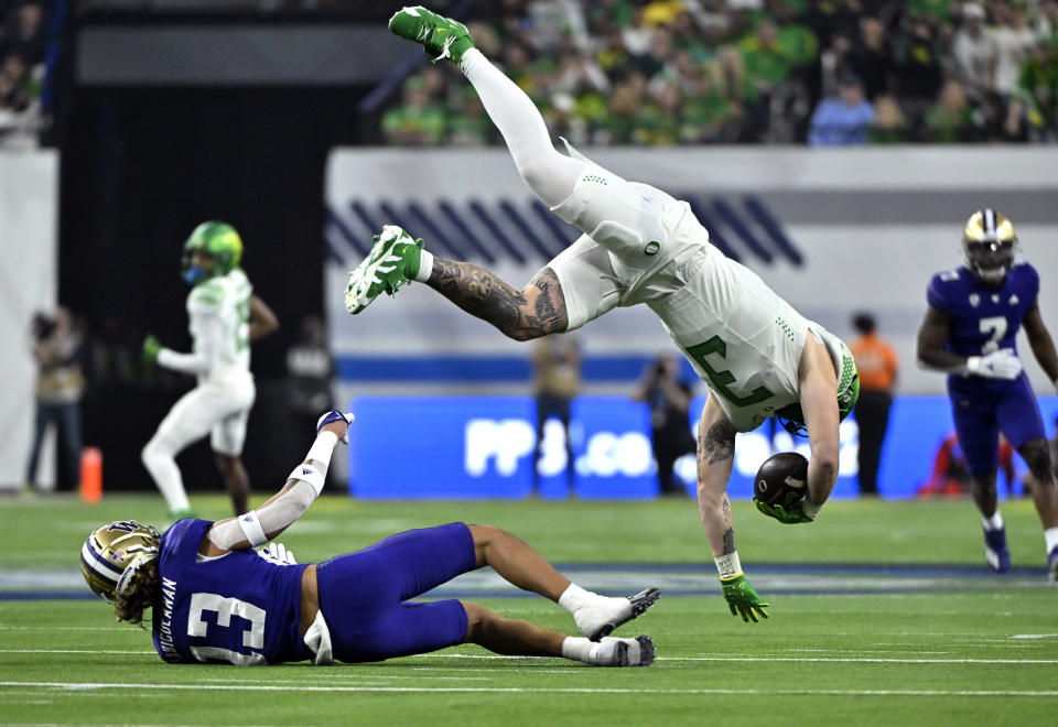 Oregon tight end Terrance Ferguson (3) is tripped by Washington cornerback Kamren Fabiculanan (13) during the first half of the Pac-12 championship NCAA college football game Friday, Dec. 1, 2023, in Las Vegas. (AP Photo/David Becker)