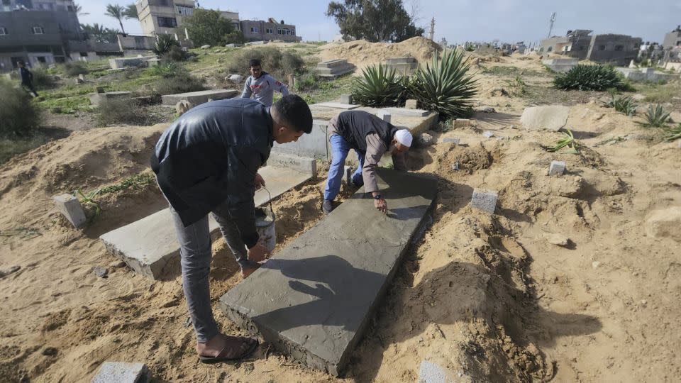 Graves are covered in cement, into which some etch epitaphs. - Mohammad Al Sawalhi/CNN