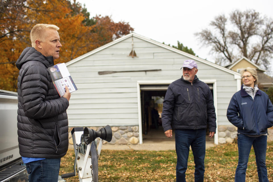 Andrew Myers, Republican candidate for the Minnesota House of Representatives District 45A, asks voters Bill Seheurer and Vicky Swanson what their priorities are while door-knocking along the eastern bank of Lake Minnetonka in Excelsior, Minn. (AP Photo/Nicole Neri)