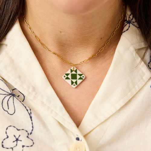 model wearing green and white star charm