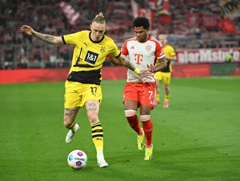 Dortmund's Marius Wolf (L) and Bayern's Serge Gnabry battle for the ball during German Bundesliga soccer match between Bayern Munich and Borussia Dortmund at the Allianz Arena. Sven Hoppe/dpa