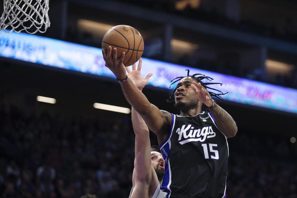 Sacramento Kings guard Davion Mitchell (15) scores past Detroit Pistons forward Joe Harris during the first half of an NBA basketball game in Sacramento, Calif., Wednesday, Feb. 7, 2024. (AP Photo/José Luis Villegas)