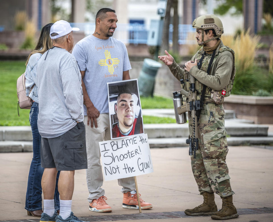 Luiz Otero, centre, holds a sign with his son Elias Otero's image, who was shot and killed a couple years ago in Albuquerque, N.M., as people attend a Second Amendment Protest in response to Gov. Michelle Lujan Grisham's recent public health order suspending the conceal and open carry of guns in and around Albuquerque for 30-days, Tuesday, Sept. 12, 2023, in Albuquerque, N.M. (AP Photo/Roberto E. Rosales)