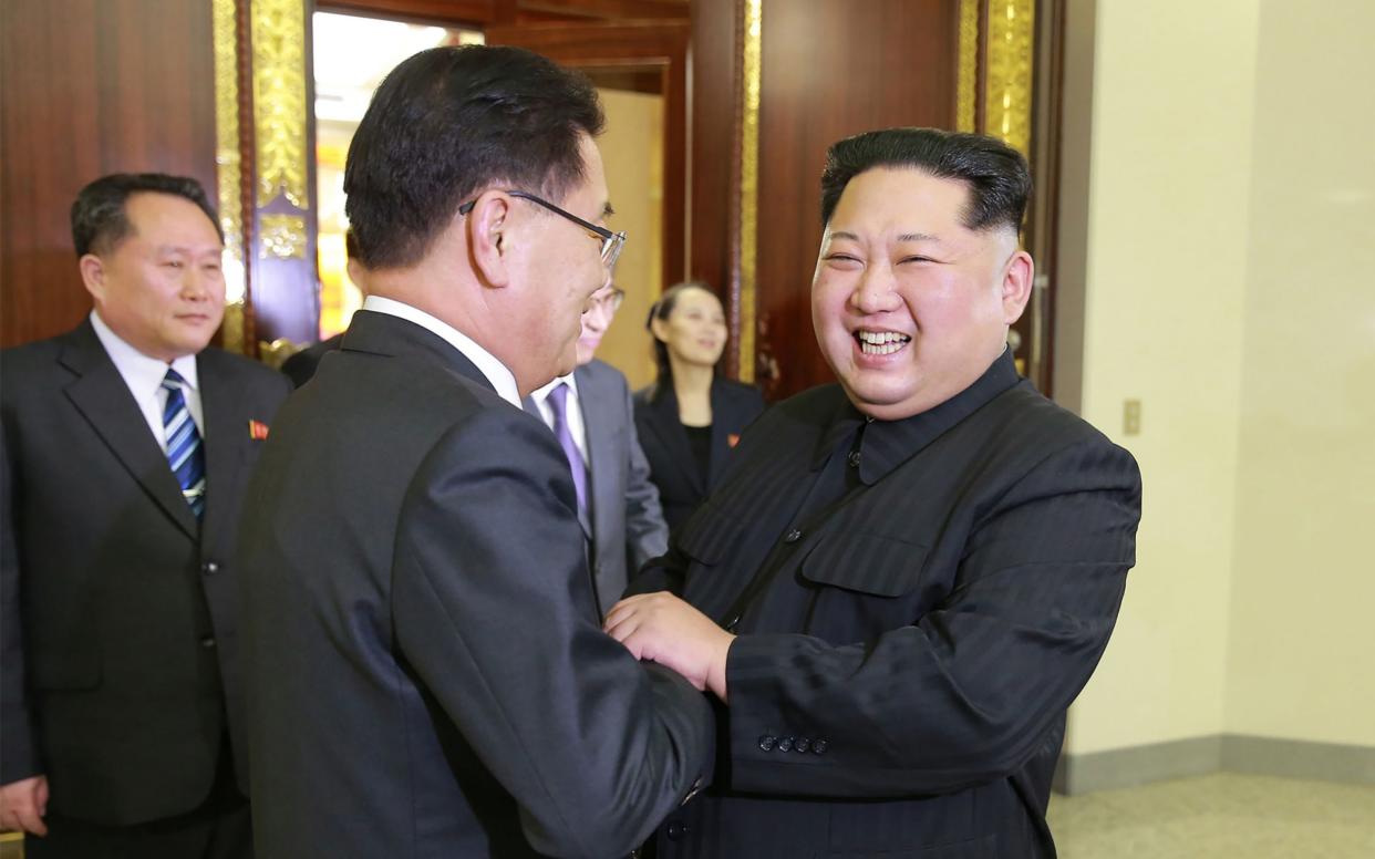 Shinzo Abe is considering a meeting with North Korean leader Kim Jong-un, pictured here shaking hands with South Korean negotiator Chung Eui-yong - AFP