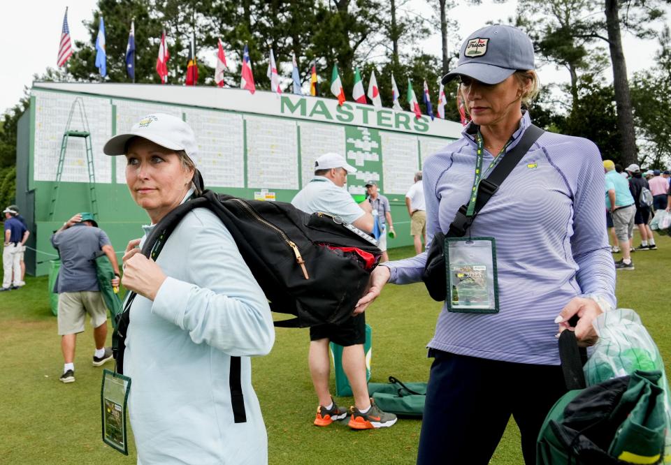 Apr 7, 2023; Augusta, Georgia, USA; Jodi Streff (right) holds Sylvia Martin's backpack near the Masters scoreboard during the second round of The Masters golf tournament. The two, both of Frisco, Texas, were sitting near the 17th tee under an umbrella to shelter from falling pinecones when multiple trees uprooted and fell to the ground where they were sitting. There was a loud crack and a man seated near them, Deshey Thomas, of Fuquay-Varina, N.C., yelled for everyone to move to safety. The group crossed the rope onto the 17th hole to evade the falling trees. Martin's bag was ripped, and Streff's chair was one of several that were crushed. Mandatory Credit: Rob Schumacher-USA TODAY Network