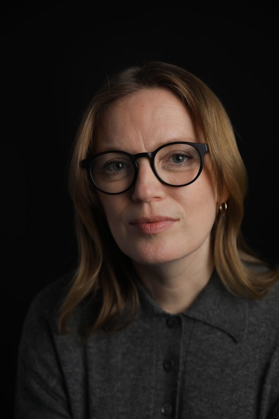 A close-up portrait of a woman with glasses