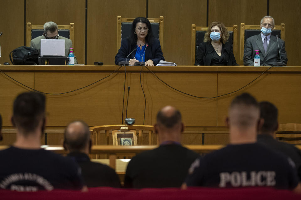 Judge Maria Lepenioti, 2nd left, delivers the verdict in a court in Athens, Wednesday, Oct. 7, 2020. The court has ruled the far-right Golden Dawn party was operating as a criminal organization, delivering landmark guilty verdicts in a politically charged five-year trial against dozens of defendants, including former lawmakers of what had become Greece's third largest party. (AP Photo/Petros Giannakouris)