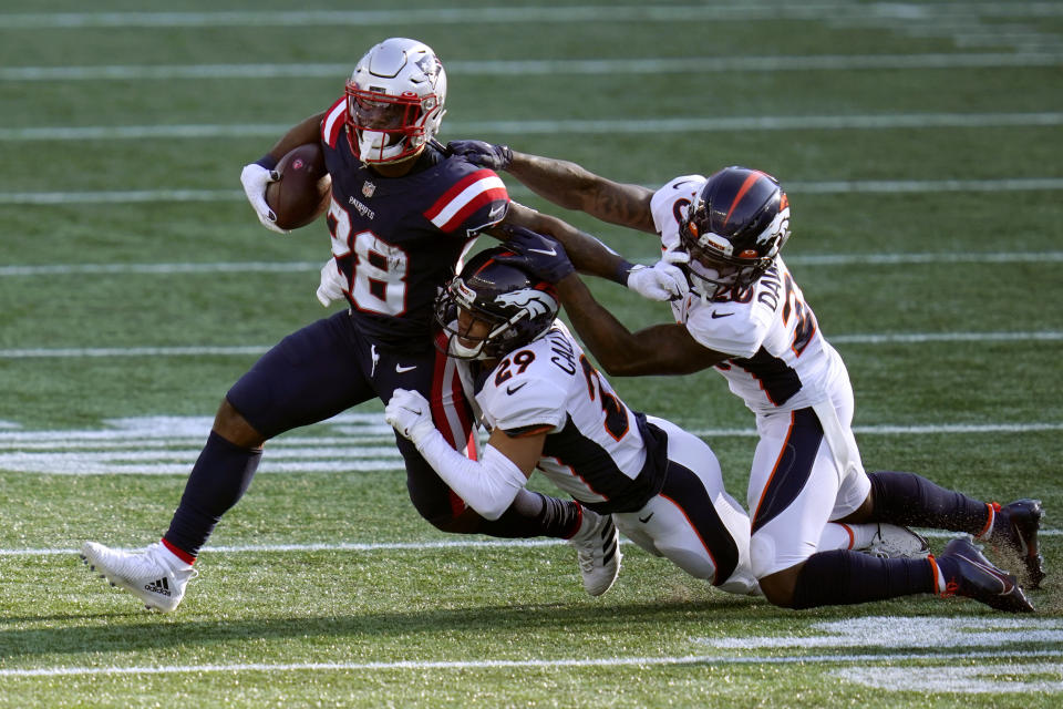 Denver Broncos cornerbacks Bryce Callahan (29) and Duke Dawson Jr. (20) tackle New England Patriots running back James White (28) in the second half of an NFL football game, Sunday, Oct. 18, 2020, in Foxborough, Mass. (AP Photo/Charles Krupa)