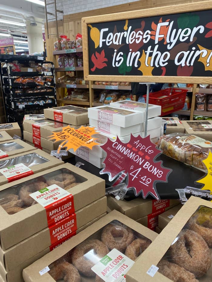 a product stand in trader joe's featuring apple cinnamon buns and apple cider donuts