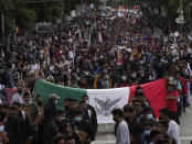 Relatives and classmates of the missing 43 Ayotzinapa college students and supporters march in Mexico City, Monday, Sept. 26, 2022, on the day of the anniversary of the disappearance of the students in Iguala, Guerrero state. Three members of the military and a former federal attorney general were recently arrested in the case, and few now believe the government's initial claim that a local drug gang and allied local officials were wholly to blame for seizing and killing the students on July 26, 2014, most of which have never been found. (AP Photo/Marco Ugarte)