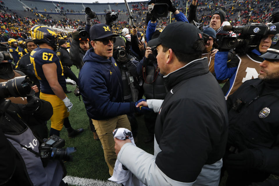 Michigan head coach Jim Harbaugh, left, shakes hands with Ohio State head coach Ryan Day after an NCAA college football game in Ann Arbor, Mich., Saturday, Nov. 30, 2019. Ohio State won 56-27. (AP Photo/Paul Sancya)